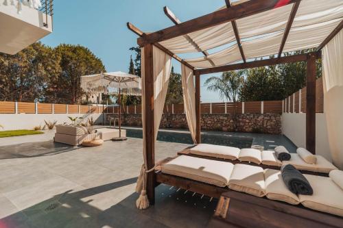 an outdoor patio with a canopy bed and a pool at Nos Aqua Villas Chania in Pazinos