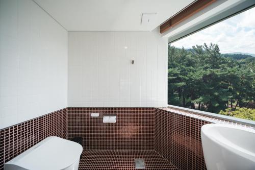 a bathroom with a toilet and a sink and a window at Kinock in Gyeongju