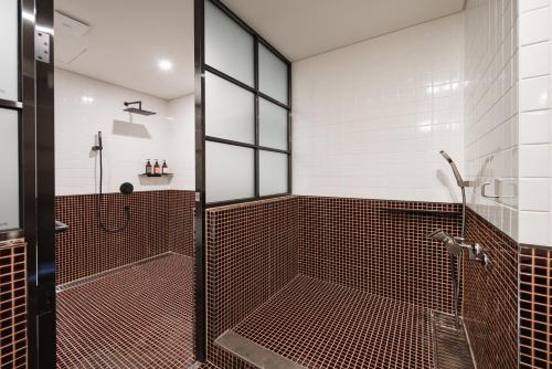 a bathroom with a shower with a glass door at Kinock in Gyeongju