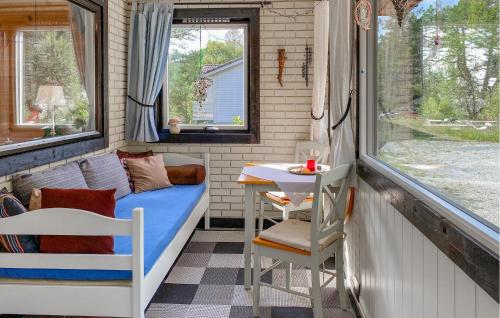 a room with a bed and a table and a window at 3 Bedroom Nice Home In Florø in Florø