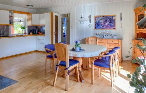 a kitchen and dining room with a table and chairs at 3 Bedroom Nice Home In Florø in Florø