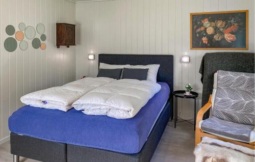 a bedroom with a blue bed with white sheets at 3 Bedroom Nice Home In Florø in Florø