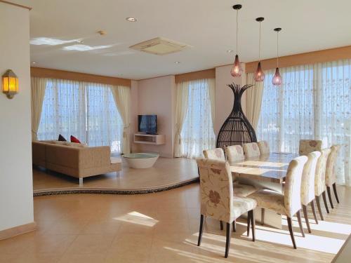 a dining room with a table and chairs and a couch at Ratana Hotel Chalong in Rawai Beach