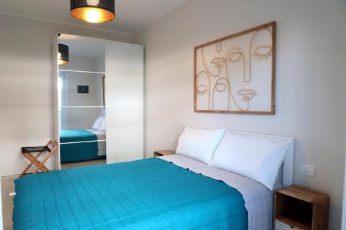 a bedroom with a blue bed and a mirror at Casa Zagara in Monopoli