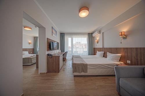 a hotel room with a bed and a couch at Cinema Hotel in Primorsko