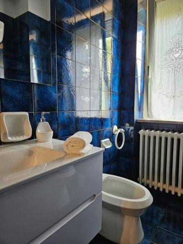 a blue tiled bathroom with a tub and a toilet at La Liva in San Silvestro