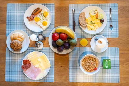 a table with plates of breakfast foods on it at Hotel Volf in Přeštice