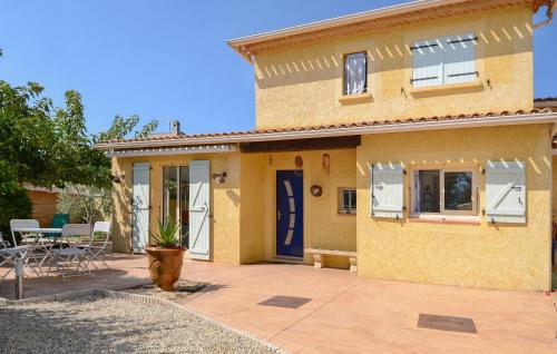 a yellow house with a blue door and a patio at Awesome Home In Marguerittes With Wifi in Marguerittes