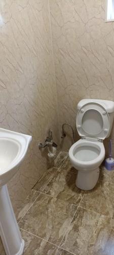 a bathroom with a toilet and a sink at Частный дом in Quba