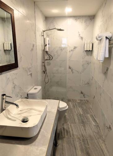 a bathroom with a sink and a toilet and a shower at Aurora Resort in Ban Pru Yai