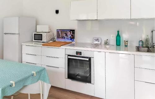 une cuisine avec des armoires blanches et un four à plaques de cuisson dans l'établissement Lovely Apartment In Saint Jean De Monts, à Saint-Jean-de-Monts