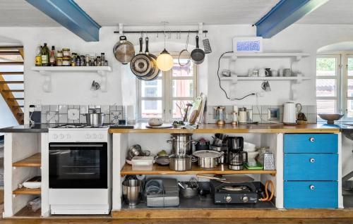 a kitchen with a white stove and some pots and pans at 3 Bedroom Awesome Home In Klemensker in Klemensker