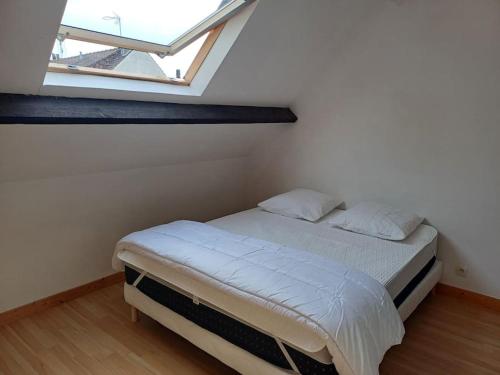 un lit dans une chambre avec une grande fenêtre dans l'établissement Maison avec terrasse Merlimont Plage, à Merlimont