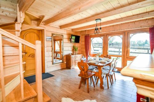 a dining room with a table and chairs in a cabin at Gazdówka na Brzyzku in Zakopane
