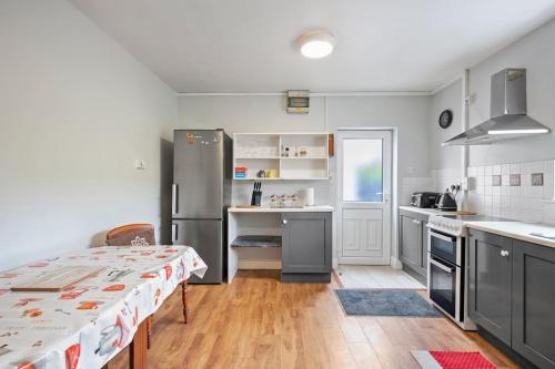 a kitchen with stainless steel appliances and a table at Home in Clonakilty in Clonakilty