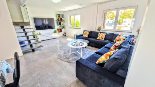a living room with a blue couch and a table at Big house with pool - 5 min walk to beach in Costa da Caparica
