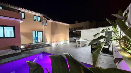 a house with a swimming pool at night at Big house with pool - 5 min walk to beach in Costa da Caparica