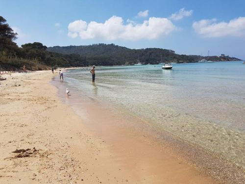 a group of people walking on the beach at Port Hyeres Duplex plein Sud 200 M2 et 100 M2 de terrasse in Hyères