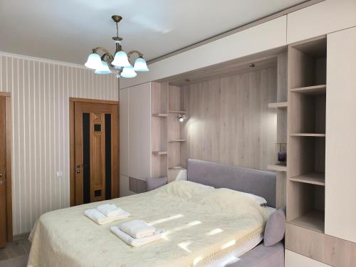 a bedroom with a bed with two towels on it at Apart Lux Melestiu in Chişinău