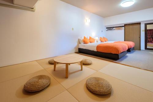 a bedroom with a king sized bed and a table at Miyazaki Mango Hotel in Miyazaki
