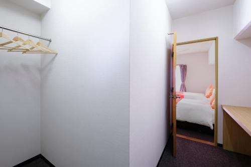 a room with a door leading to a bedroom at Miyazaki Mango Hotel in Miyazaki