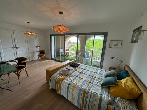 a bedroom with a bed and a table and chairs at Port Hyeres Duplex plein Sud 200 M2 et 100 M2 de terrasse in Hyères