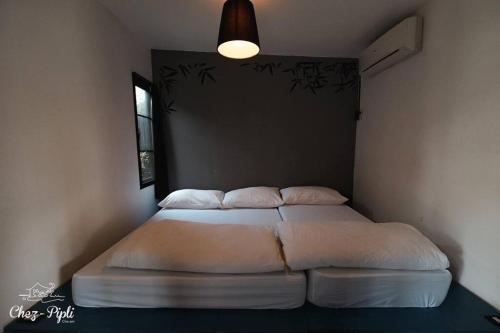 two twin beds in a bedroom with a lamp at La Mer ลาแมร์ in Cha Am Beach