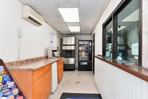 a kitchen with a counter and a refrigerator at Americas Best Value Inn - Port Jefferson Station - Long Island in Port Jefferson Station