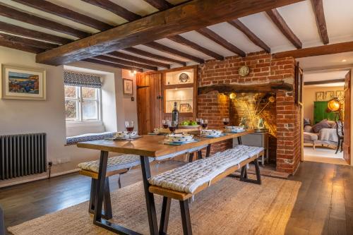a living room with a table and a brick fireplace at Gable End in Great Snoring