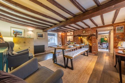 a living room with a table and chairs and a fireplace at Gable End in Great Snoring