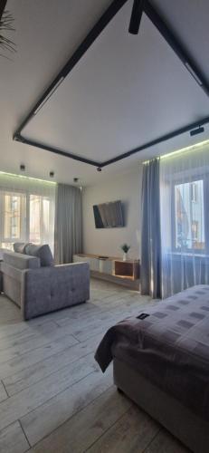 ein Schlafzimmer mit einem Bett, einer Couch und einem Fernseher in der Unterkunft Апартаменты на Чехова in Öskemen