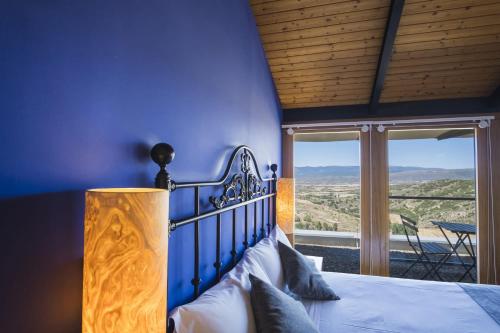 a bedroom with a bed with a blue wall at Hotel Alda Triskel in Sos del Rey Católico
