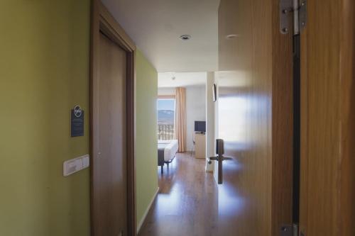a hallway with a room with a bed and a window at Hotel Alda Triskel in Sos del Rey Católico