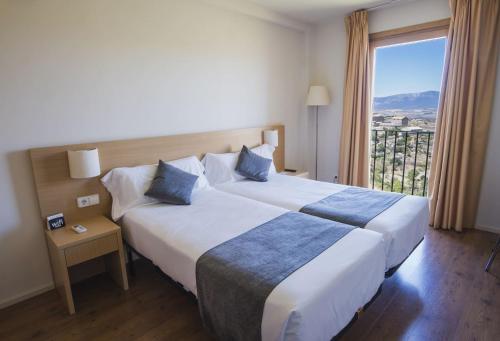 a hotel room with a large bed and a window at Hotel Alda Triskel in Sos del Rey Católico