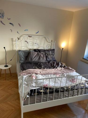a bedroom with a white bed with a metal frame at Janko's house in Maribor