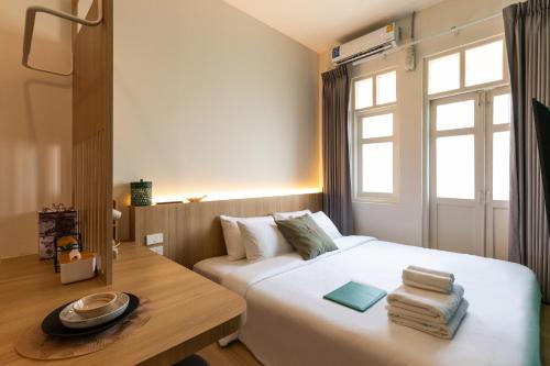 a bedroom with a white bed and a window at Belivin99 Residence Chinatown in Bangkok