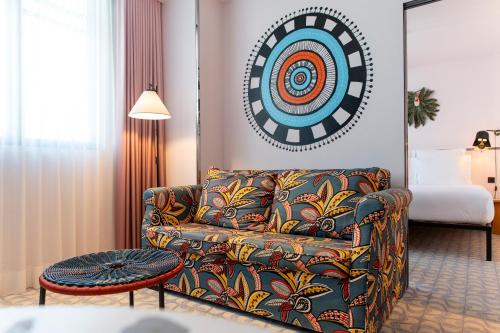 a living room with a couch and a target on the wall at Mama Shelter Lisboa in Lisbon