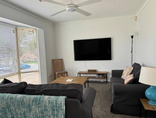 a living room with a couch and a flat screen tv at Welcome to Jim's Place! in Perth