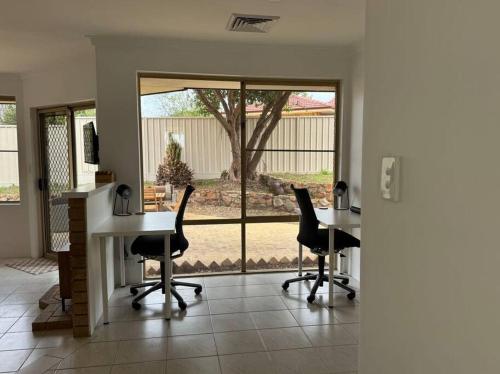 an office with two desks and chairs and a large window at Welcome to Jim's Place! in Perth