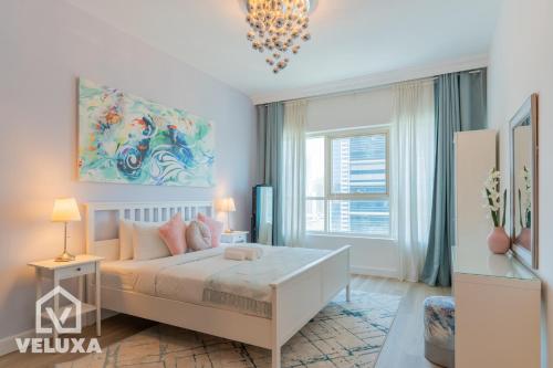 a bedroom with a bed and a large window at Veluxa - Renovated! La Maison des Artist in Dubai