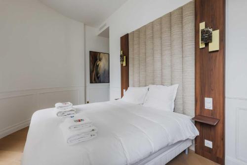 une chambre avec un lit blanc avec des serviettes dessus dans l'établissement Charming flat - 2BR- 6P - Arc de Triomphe, à Paris