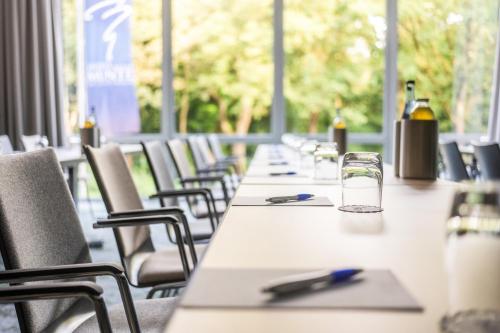 a row of tables and chairs with bottles on them at MUNTE - Wellnesshotel am Stadtwald in Bremen