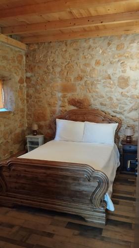a bedroom with a bed in a stone wall at Casa do casal POIOS in Pombal