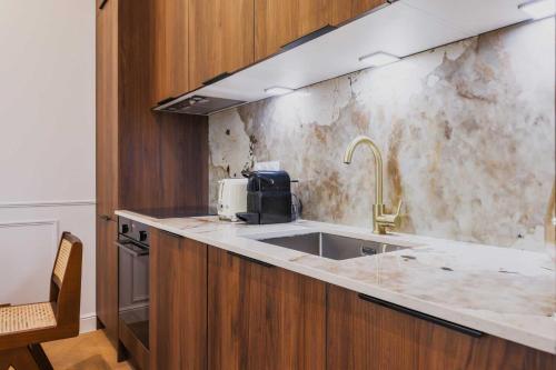 une cuisine avec un évier et un plan de travail dans l'établissement Cosy flat - 1BR- 4P - Arc de Triomphe, à Paris