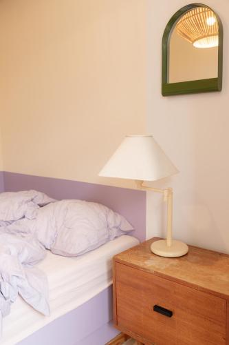 a bedroom with a bed and a lamp on a dresser at Hostel Ani&Haakien in Rotterdam