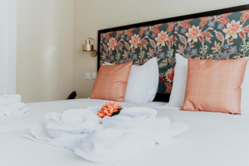 a white bed with a flower on top of it at King Charles Hotel in Valletta