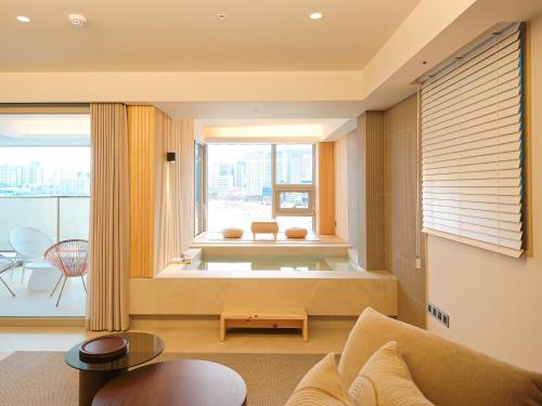 a living room with a couch and a large window at B'amu Hotel in Busan
