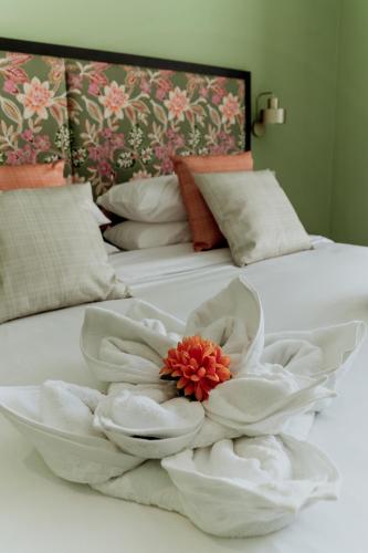 a bed with white towels and a flower on it at King Charles Hotel in Valletta