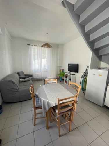un salon avec une table, des chaises et un canapé dans l'établissement Maison 300 m de la plage, à Châtelaillon-Plage