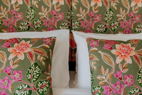 two pillows on a bed with floral wallpaper at King Charles Hotel in Valletta